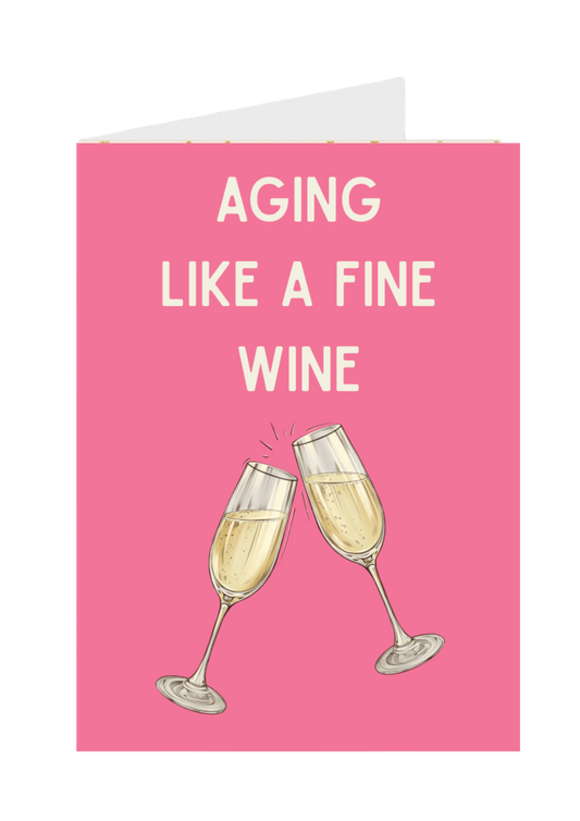 Greeting card with two champagne glasses and text 'Aging Like a Fine Wine' on a pink background